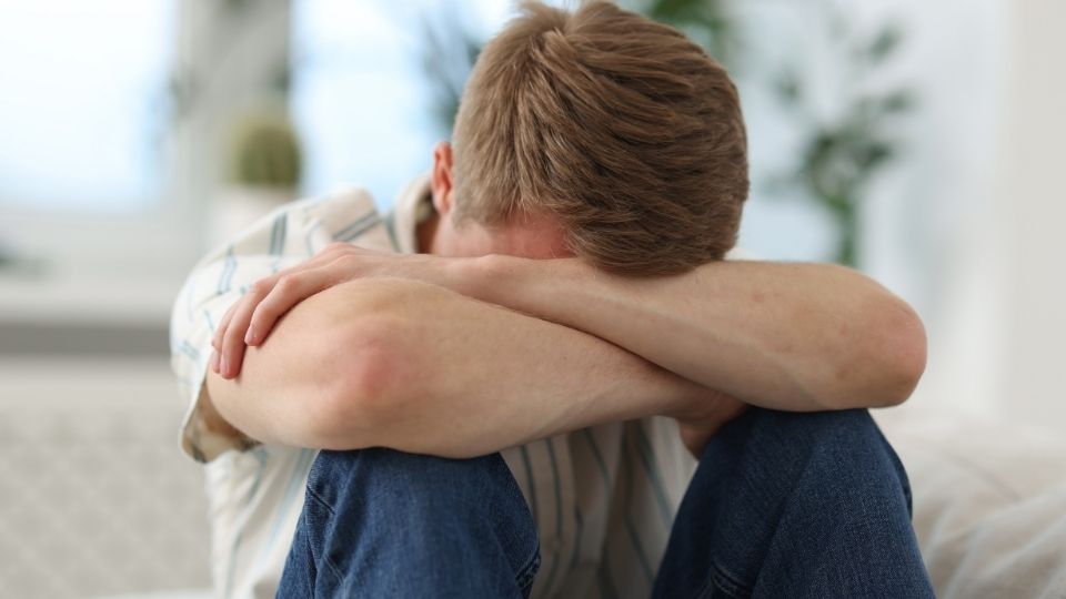 Is Valium Addictive? a man experiences the effects of addiction while crouched and his head down.