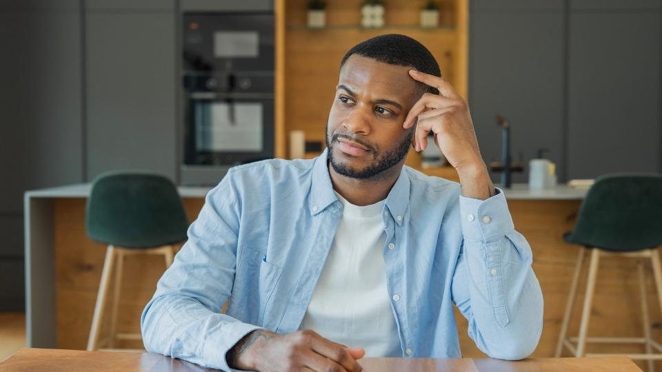 Kratom Side Effects hero image of a man thinking about withdrawal risks associated with Kratom.